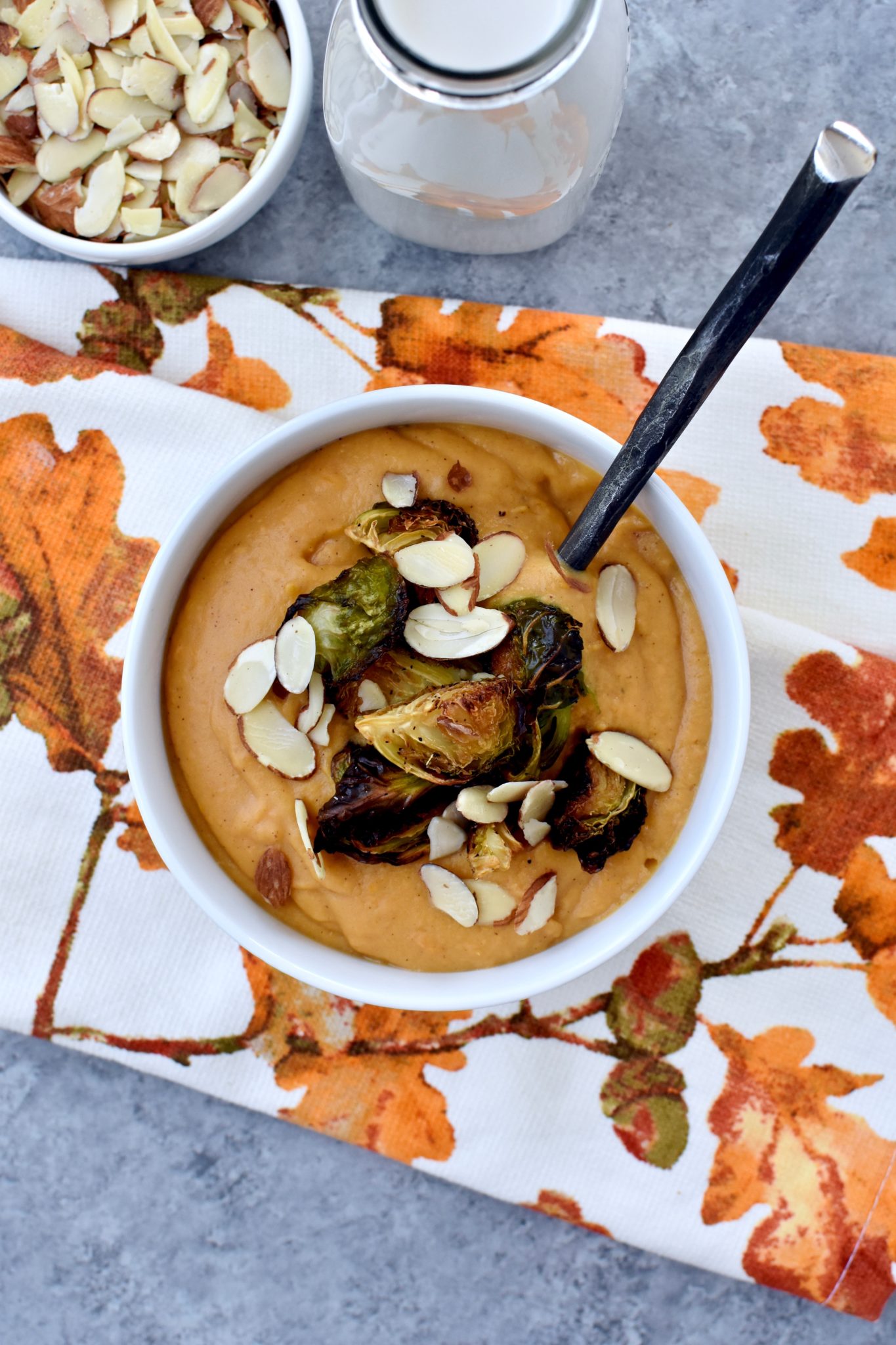 creamy sweet potato soup with roasted parmesan brussel sprouts and sliced almonds